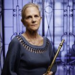 Carol Lynn Ward-Bamford holding the DCM 10, the flute that Dayton C. Miller made by hand in 22k gold, with 18k keys. Photo by Shawn Miller/Library of Congress.